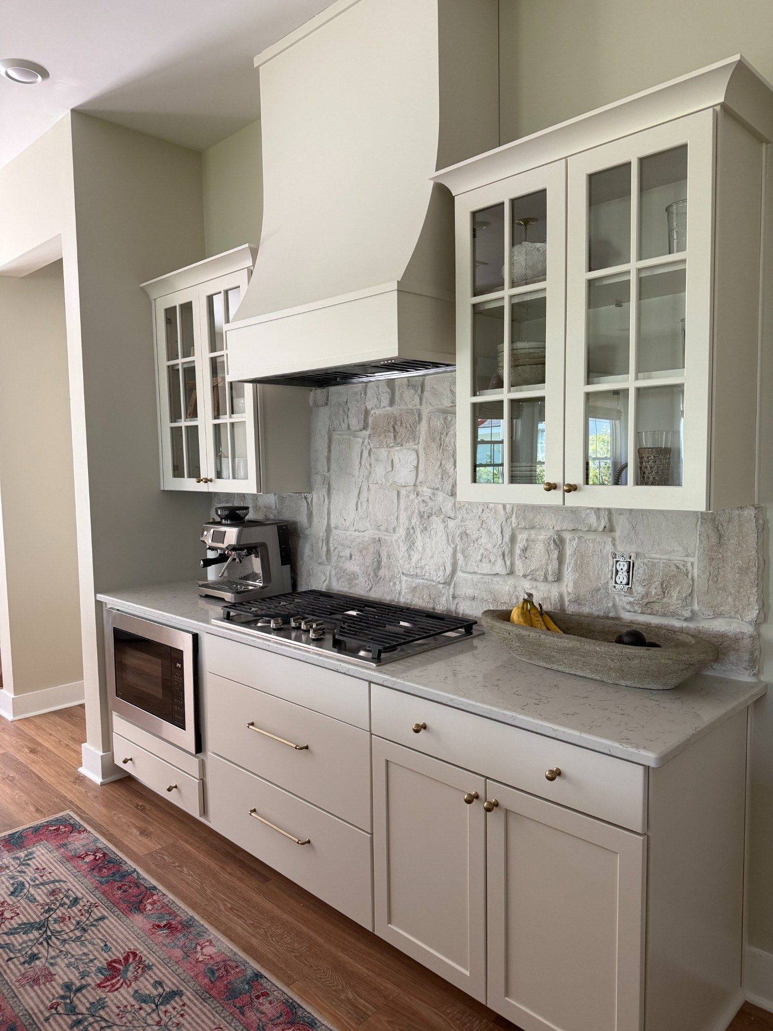 Custom kitchen renovation with painted cabinetry and stone backsplash